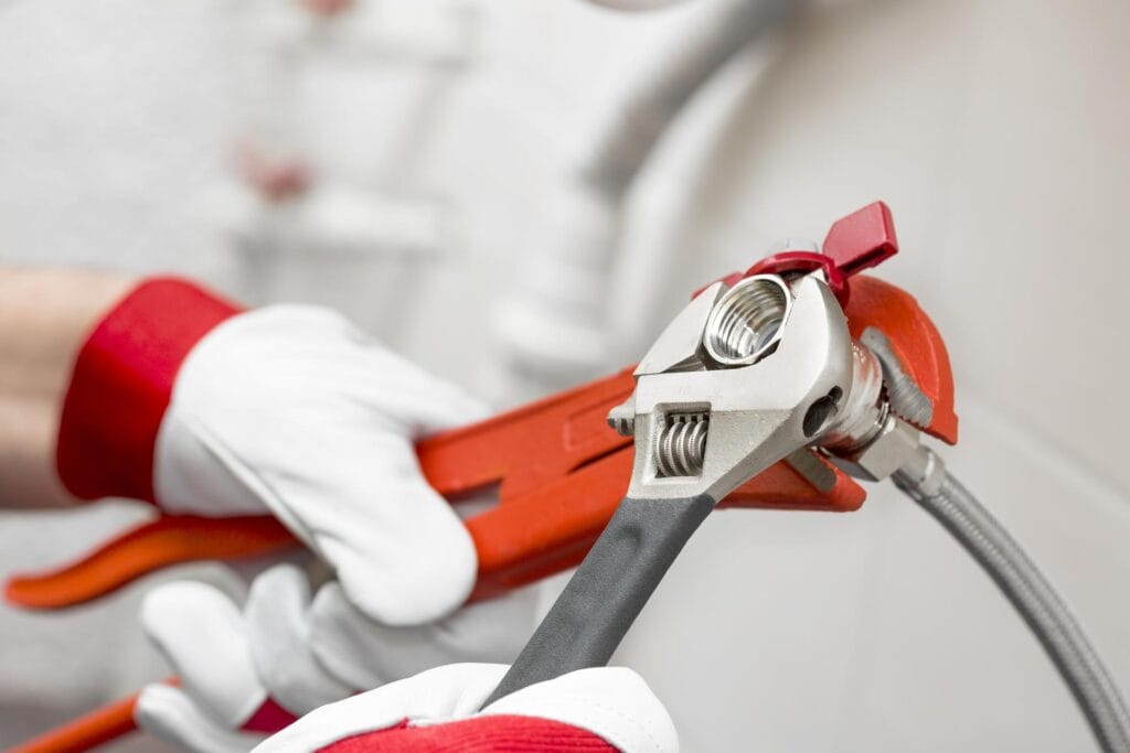 Plumber holding pipe wrenches for an emergency repair in Bullhead City