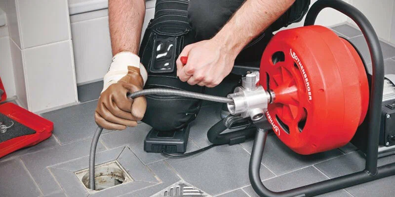 Plumber using a drain-cleaning machine in Bullhead City