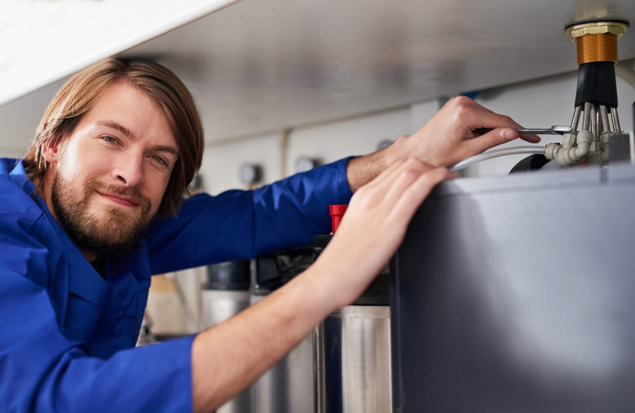 Technician servicing a residential water heater tank in Bullhead City